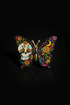 Black butterfly pin with Day of the Dead sugar skull and marigold florals