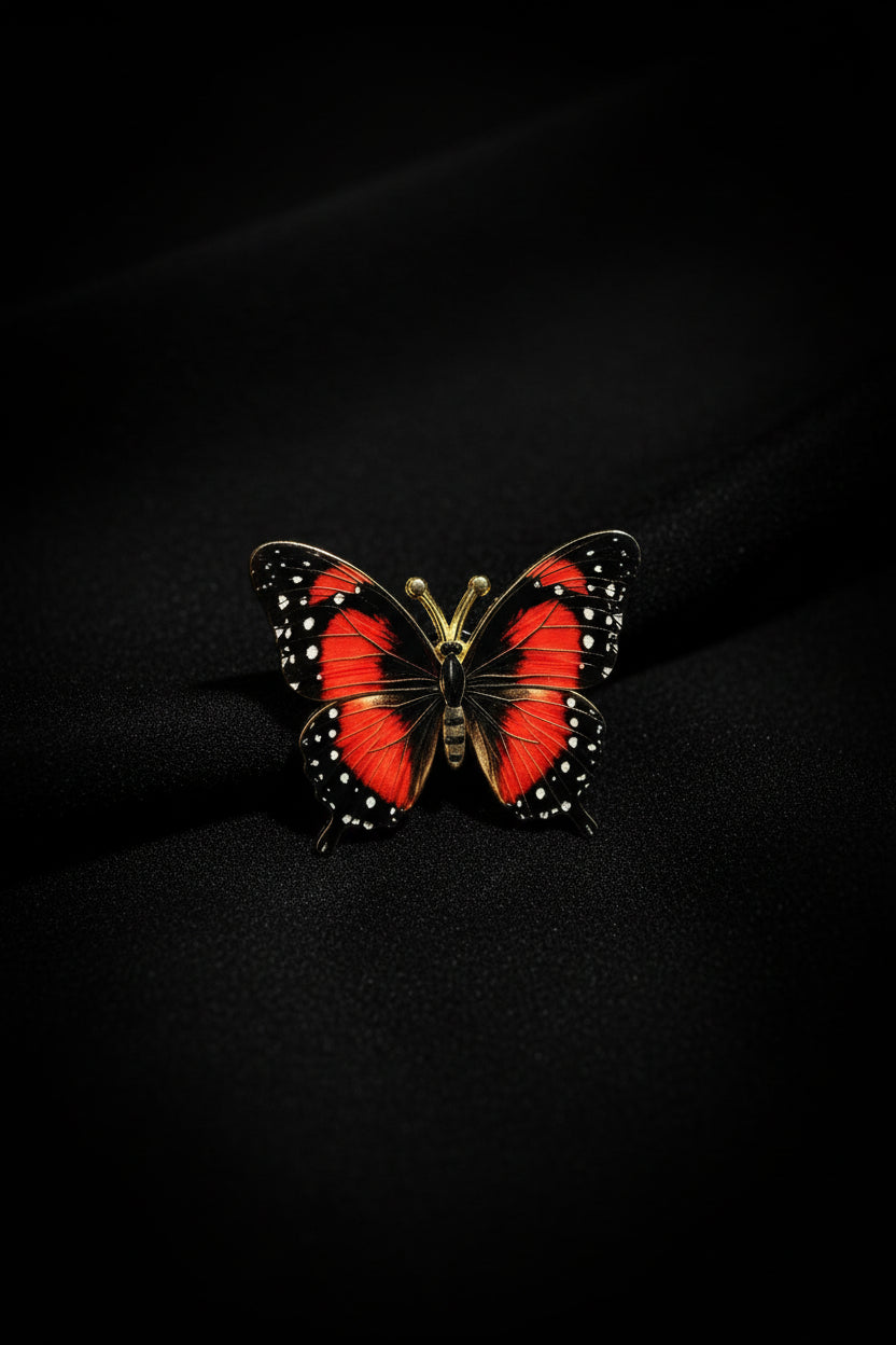 Red and black butterfly pin with white dot accents