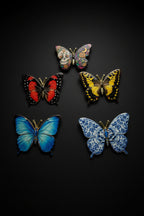 All five Becoming Collection Luminous Series butterfly pins on white fur